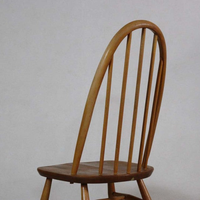 Mid-century British vintage Ercol Quaker dining chair in teak with curved spindle back and tapered legs.