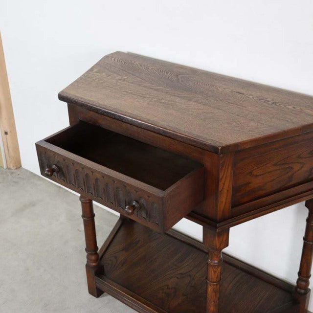 Vintage teak bedside cabinet with rich wood grain, turned legs, single drawer, and lower shelf, British mid-century style.