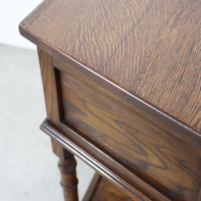 Mid-century British teak bedside cabinet with rich wood grain and turned legs, vintage Denmark style.