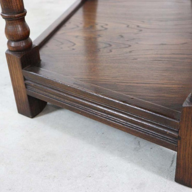 Corner detail of vintage British mid-century teak bedside cabinet showing rich wood grain, turned leg, and sturdy base design.