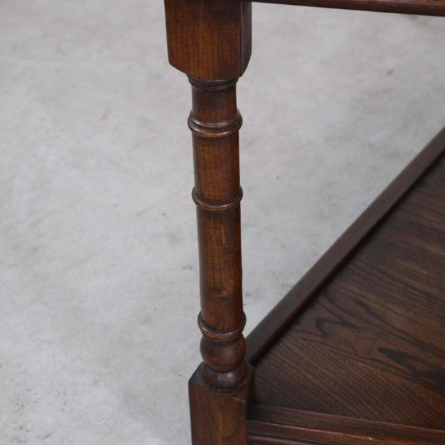 Close-up of vintage British teak bedside cabinet leg with turned mid-century design and rich wood grain.
