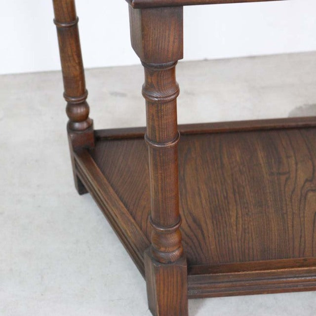 Close-up of vintage British mid-century teak bedside cabinet leg and wood grain with turned detailing and lower shelf edge.