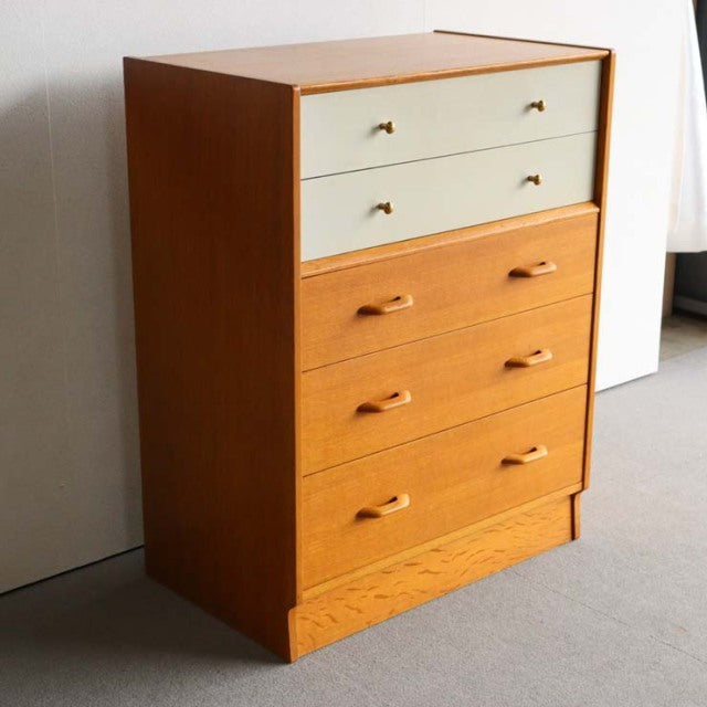 Vintage mid-century G-Plan teak chest with Chinese white top drawers, brass handles, and clean British design from Denmark.