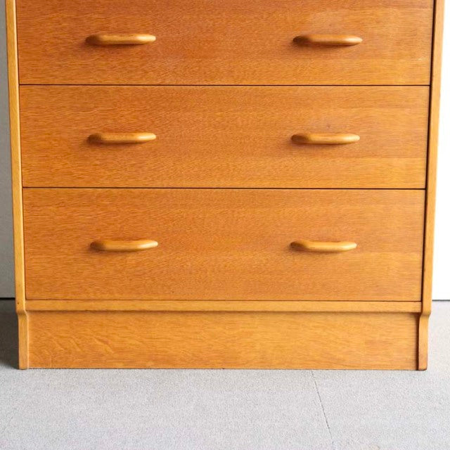 Vintage teak G-Plan mid-century British chest with smooth wood grain and curved handles.