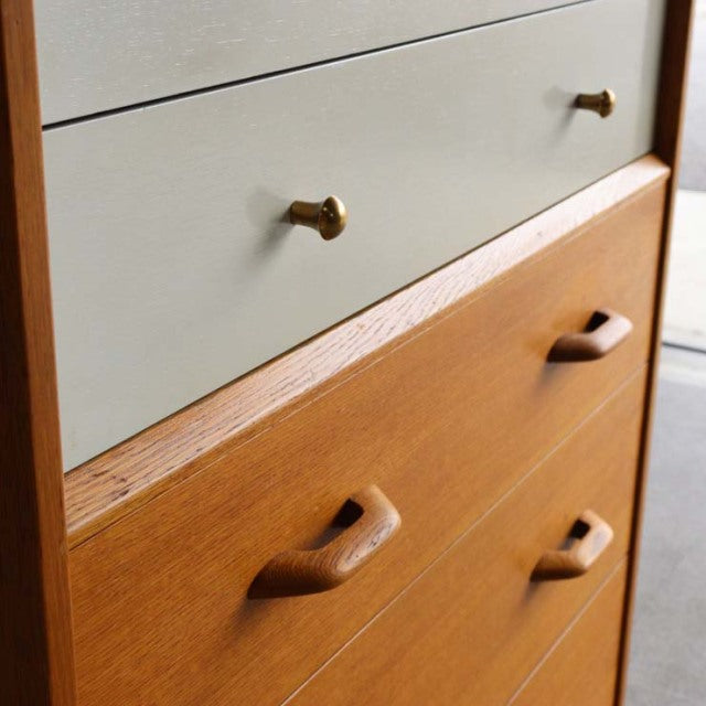 Vintage mid-century G-Plan teak and Chinese white chest with brass and wooden handles, sleek Scandinavian design.