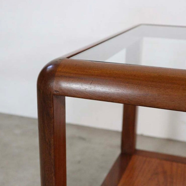 British vintage mid-century teak coffee table with rounded corners and a clear glass top.