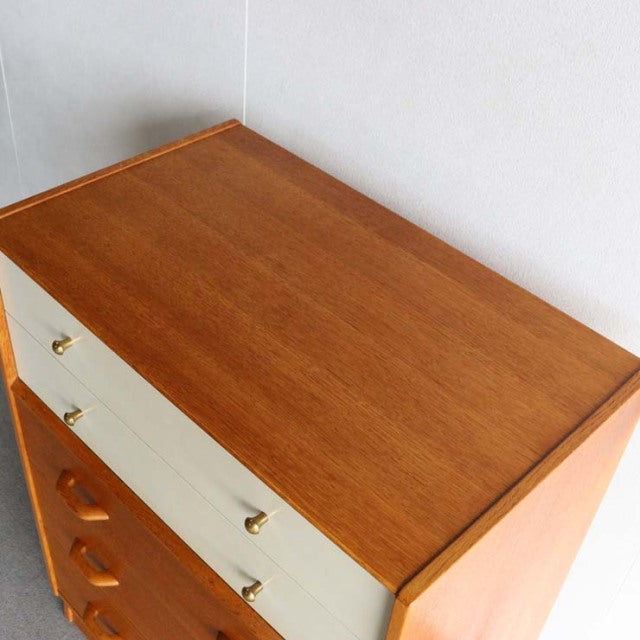 Vintage mid-century teak and Chinese white G-Plan chest with brass knobs and tapered British-style legs.
