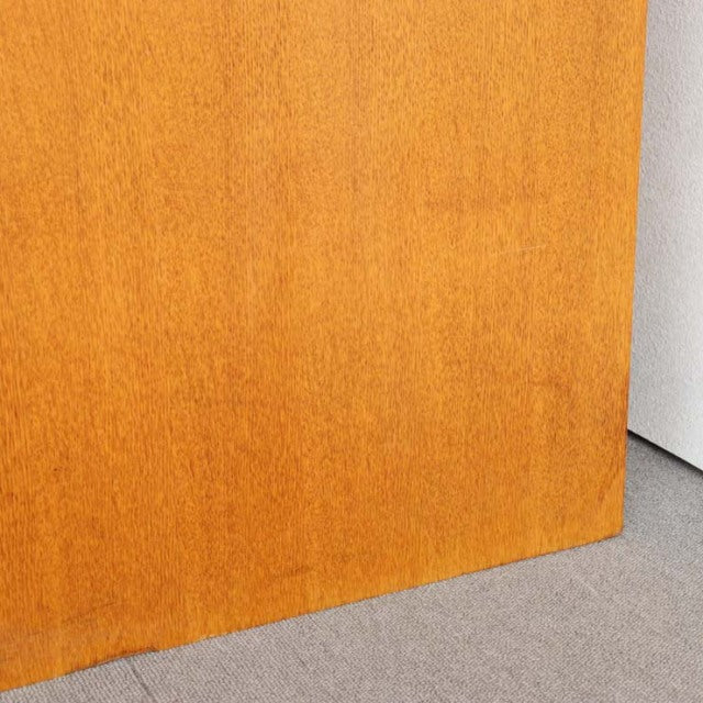 Close-up of smooth teak wood panel with warm honey tone and fine grain, featuring a subtle mid-century British G-Plan finish.