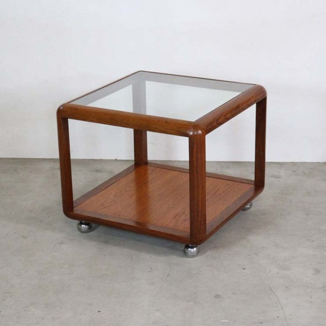 Vintage G-Plan mid-century teak cube coffee table with glass top and rounded wood frame on metal caster feet.