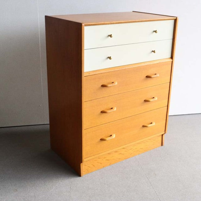 Vintage mid-century G-Plan teak chest with clean lines, Chinese white top drawers, and brass handles.