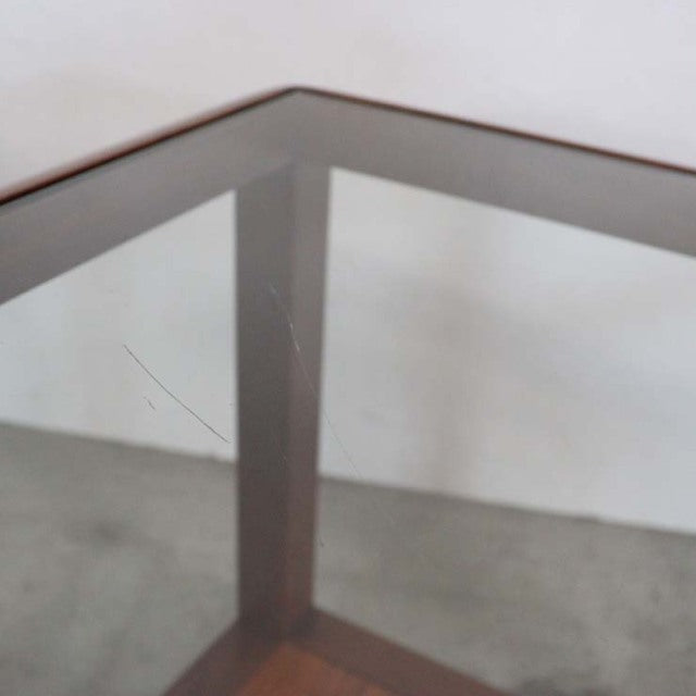 Vintage British mid-century teak coffee table with cube-shaped frame and clear glass top, showcasing rich wood grain and.