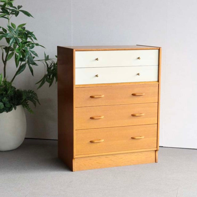 Vintage G-Plan mid-century teak chest with Chinese white upper drawers, sleek wooden handles, and tapered legs.