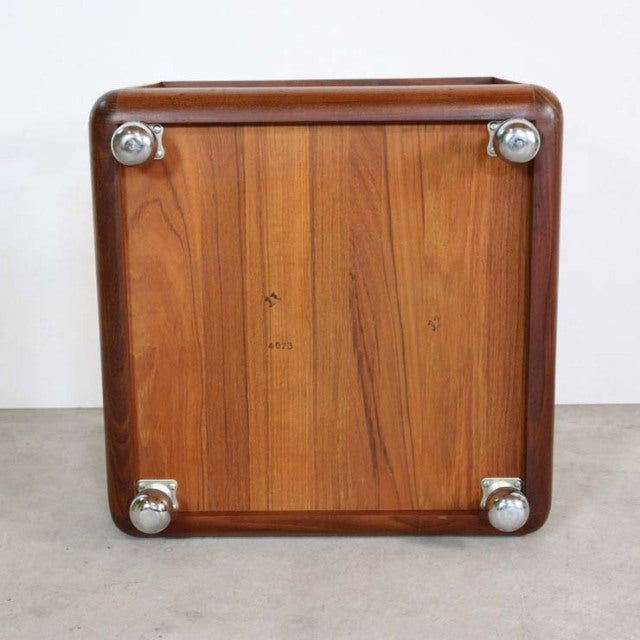 Vintage British G-PLAN mid-century teak cube coffee table base showing rich wood grain and metal caster wheels.