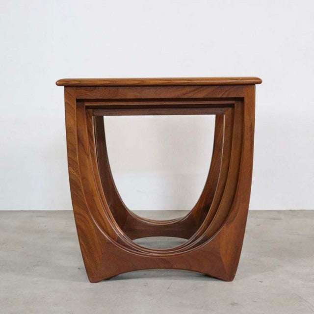 Vintage G-Plan teak nest table with smooth curved legs and rich mid-century British wood grain finish.