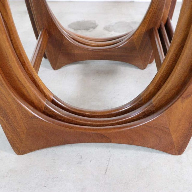 Vintage teak G-Plan mid-century British nest tables with smooth curved legs and rich wood grain detailing.