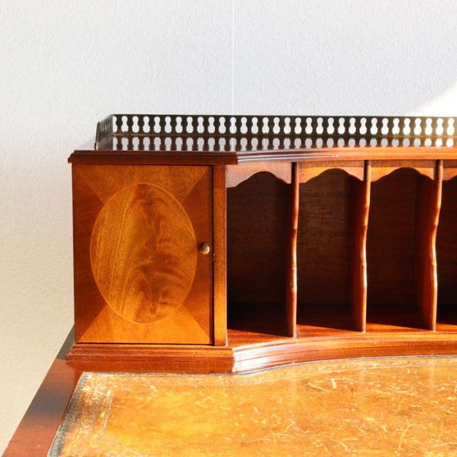 Vintage British mid-century teak desk organizer with intricate wood grain, spindle railing, and segmented compartments on a.