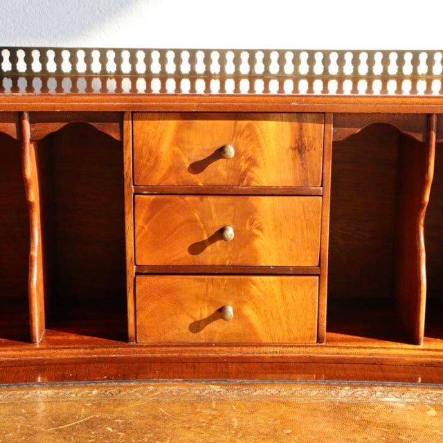 Vintage teak British mid-century desk with three central drawers, rounded handles, detailed wood grain, and spindle railing.