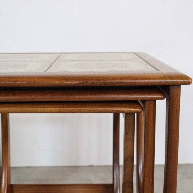 Vintage British G-Plan teak nest tables with mid-century design, square tile tops, and slender rounded legs.