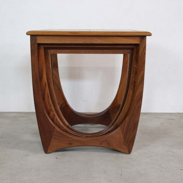 Vintage teak G-Plan mid-century British nest table with curved legs and smooth wood grain finish.