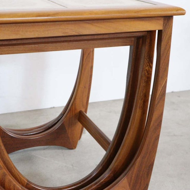 Vintage G-Plan teak nest table corner with curved British mid-century legs showing rich wood grain and smooth finish.
