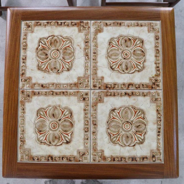 Vintage British mid-century G-Plan teak nest table with four decorative ceramic tiles featuring floral patterns and.