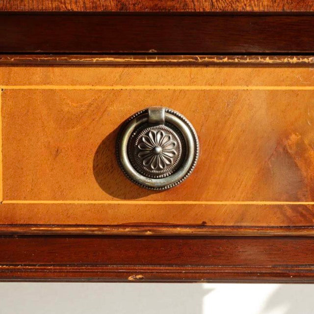 Close-up of vintage British mid-century teak desk drawer with decorative floral metal pull and detailed wood grain.