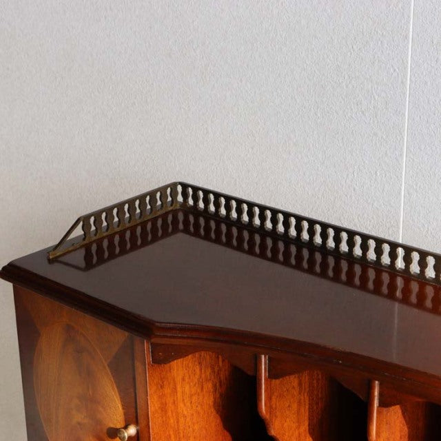 Vintage mid-century British teak desk with rich wood grain, brass gallery rail, and angled corners.