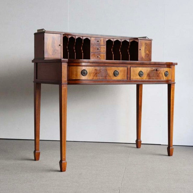 Vintage British teak desk with mid-century design, featuring tapered legs, two front drawers, and a raised back organizer.