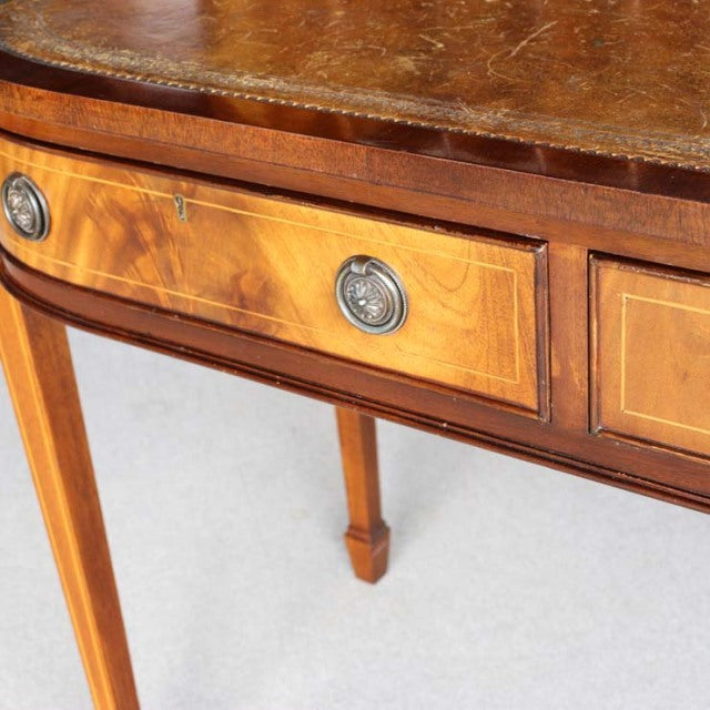 Vintage British teak desk with mid-century design, decorative drawer pulls, tapered legs, and distinct wood grain detailing.