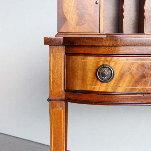 Mid-century British vintage teak desk corner with rich wood grain, brass drawer knob, and elegant tapered leg detailing.