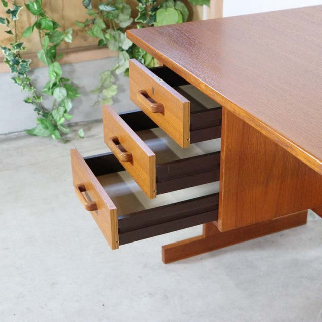 Mid-century vintage teak desk with three open drawers, clean lines, and solid wood grain from Denmark.
