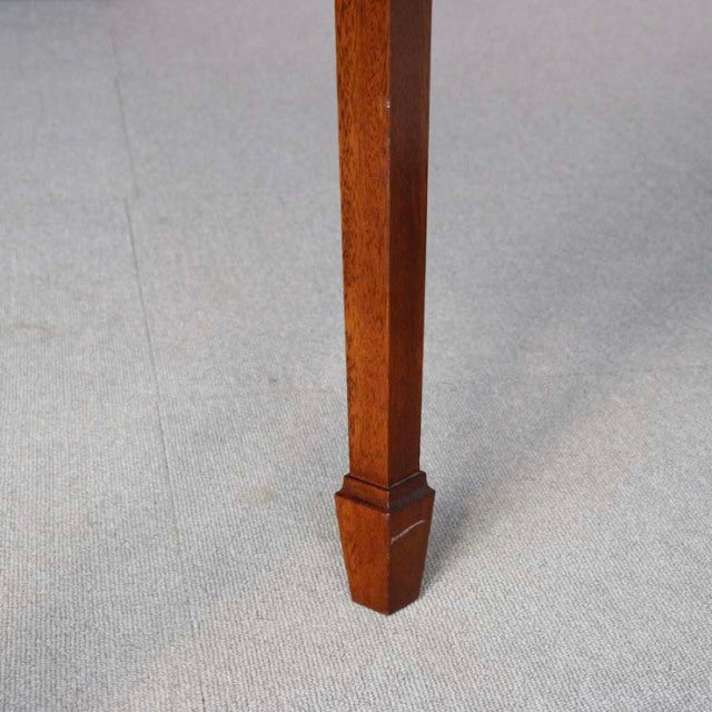 Close-up of a vintage teak desk leg with mid-century British design, showcasing rich wood grain and tapered square profile.