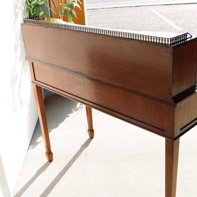 Vintage British mid-century teak desk with sleek tapered legs and rich wood grain detail.