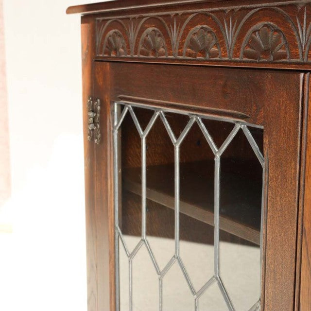 Vintage teak mid-century British cabinet by Jaycee with carved detailing and geometric leaded glass door panel.