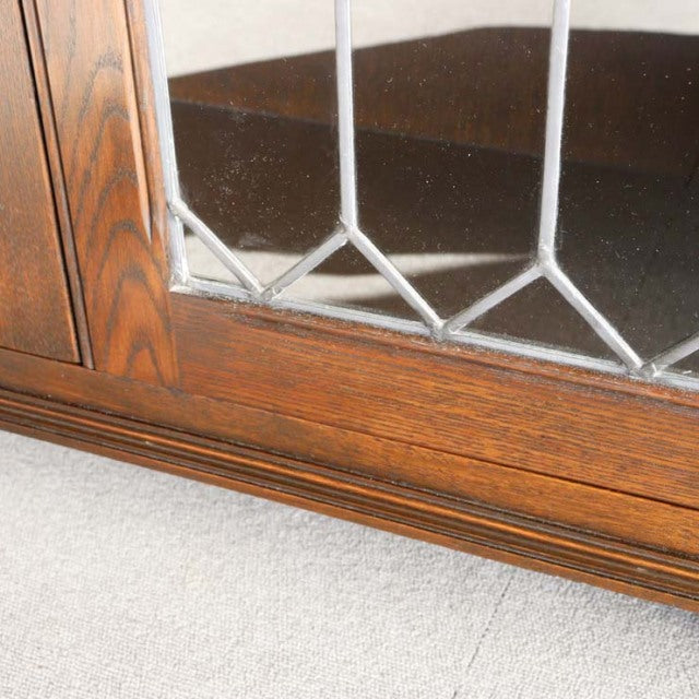 Close-up of vintage teak British mid-century Jaycee cabinet corner with detailed wood grain and leaded glass panel.