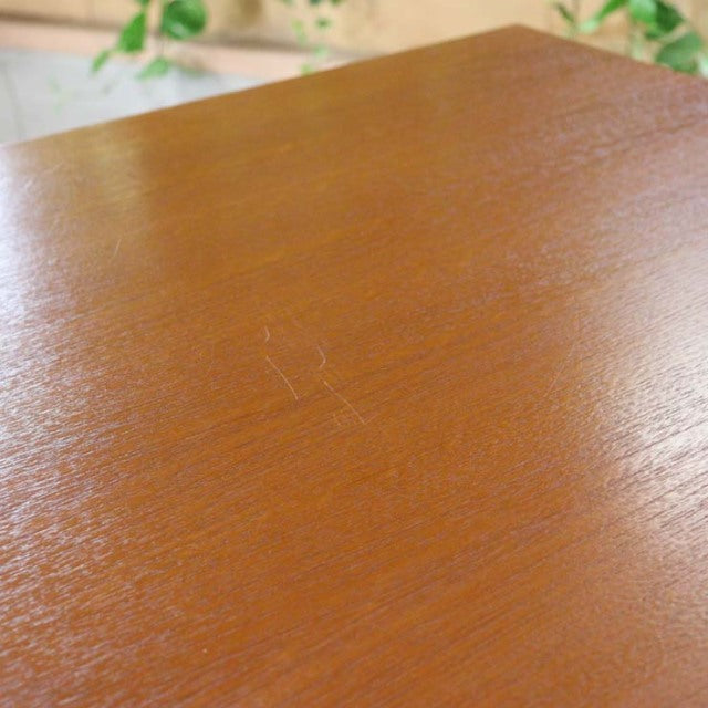 Close-up of vintage teak desk surface showcasing rich wood grain and mid-century Danish craftsmanship.