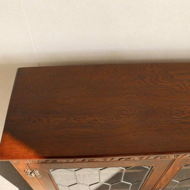 Vintage teak mid-century British cabinet by Jaycee with rich wood grain and hexagonal glass panes.