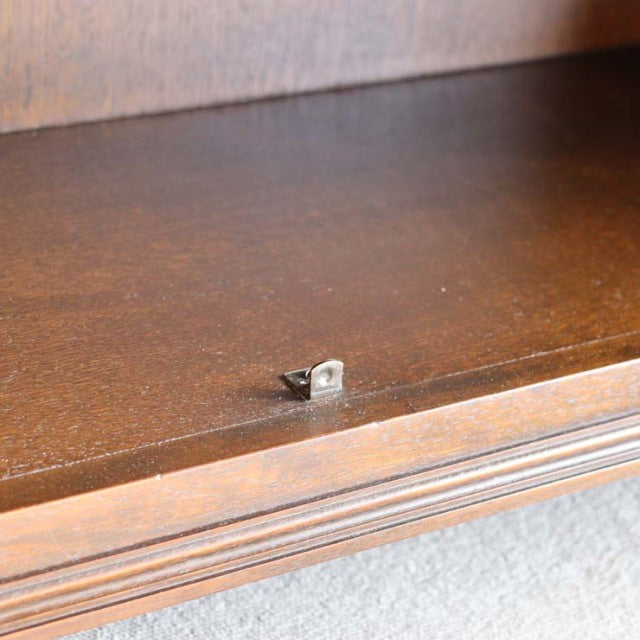 Close-up of vintage British teak cabinet shelf with rich wood grain and grooved edge detail.