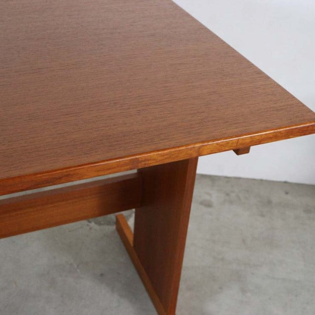 Mid-century vintage teak desk corner showing smooth wood grain and clean-lined Danish design legs.
