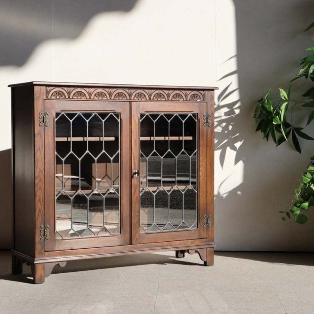 Vintage teak mid-century Jaycee British cabinet with glass paneled doors and detailed wood grain.