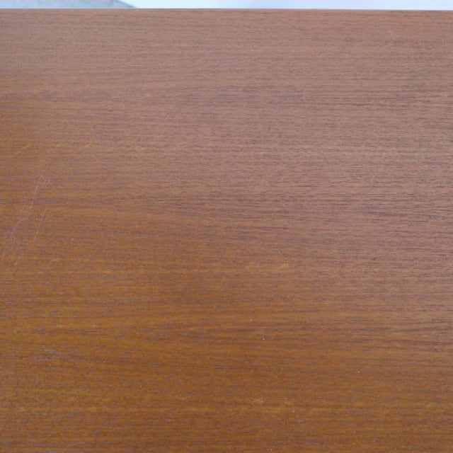 Close-up of vintage teak wood desk surface showcasing smooth mid-century Danish grain and warm British finish.
