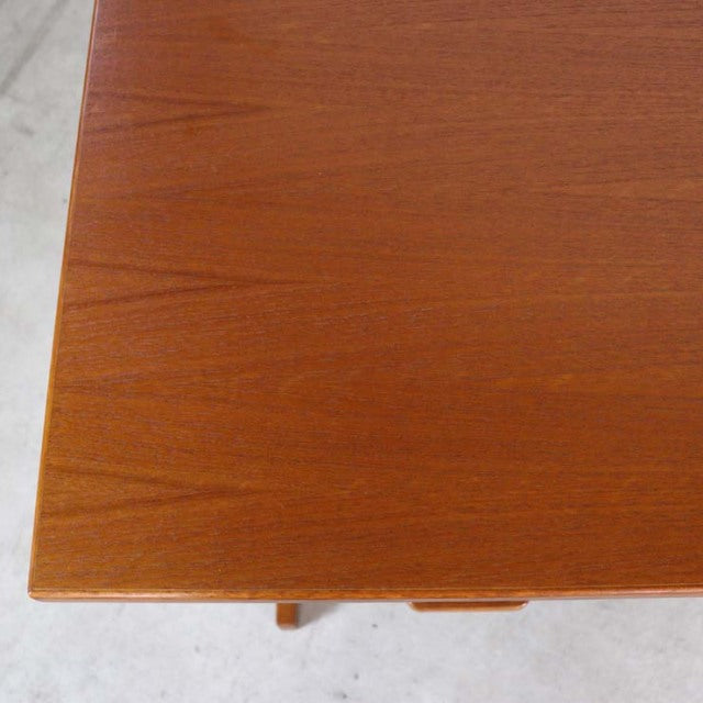 Close-up of vintage Danish mid-century teak desk corner with smooth wood grain and clean edges.