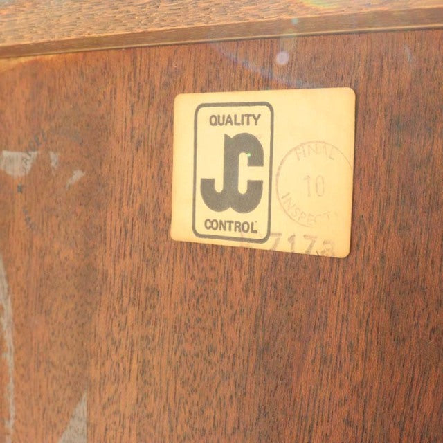 Close-up of British Jaycee teak cabinet showing vintage mid-century wood grain and quality control label.