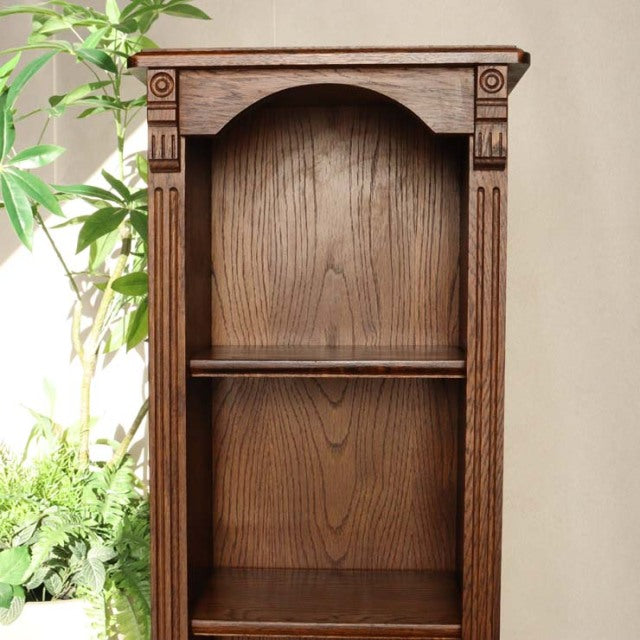 Vintage British oak cabinet with rich wood grain, mid-century design, and carved column details.