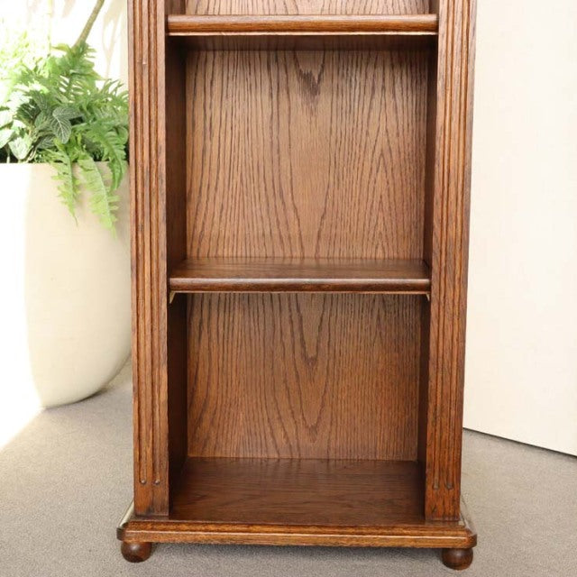 Vintage teak cabinet with rich wood grain, mid-century British design, slender vertical form, and rounded feet.