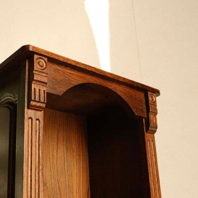 Vintage teak cabinet with British mid-century design, detailed wood grain, ornate carved legs and arch top.