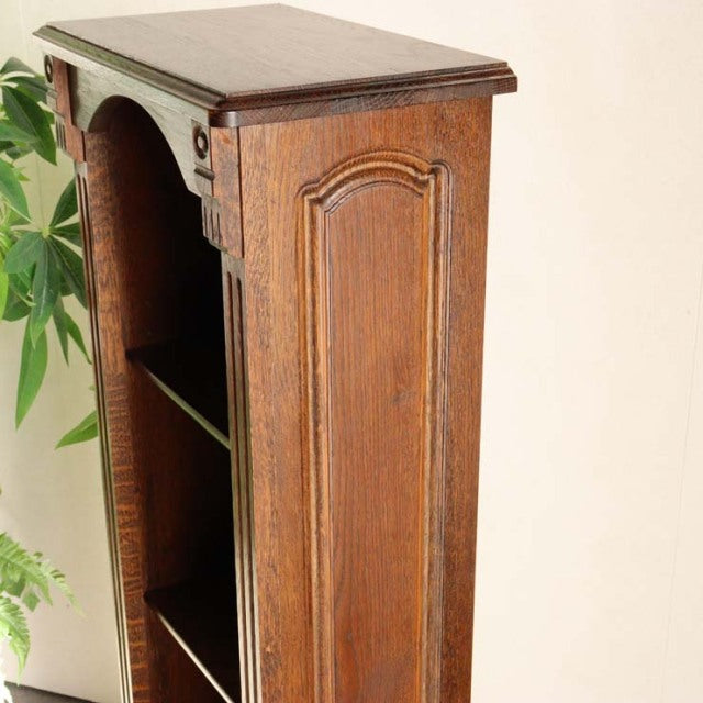 Vintage British mid-century oak cabinet with ornate carved details, raised legs, and rich wood grain.