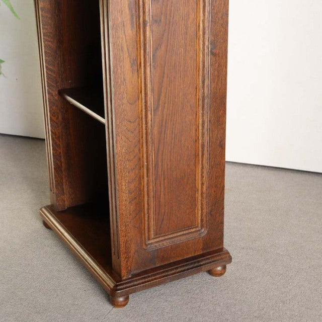 Vintage teak British mid-century cabinet corner showing rich wood grain, paneled side, and rounded bun feet.