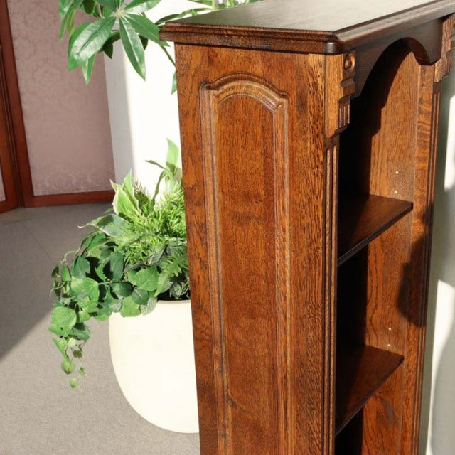 Vintage British mid-century teak cabinet with rich wood grain, ornate side panel, and tapered legs.