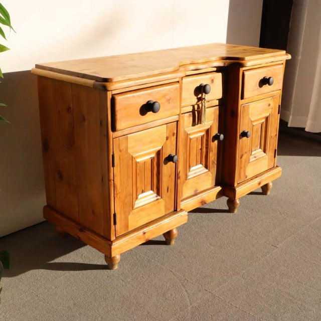 Vintage teak sideboard with British mid-century design, detailed wood grain, sturdy legs, and black metal handles.